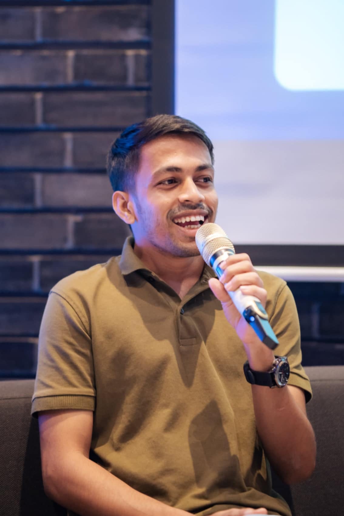 Miraz smiling while speaking into a microphone during the media literacy panel